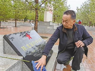 <p>　　仔细擦拭烈士墓碑。</p>