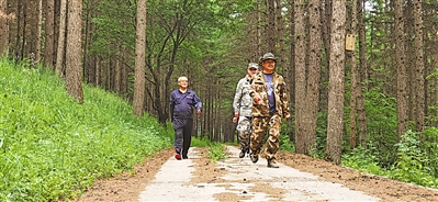 <p>　　　　张建国（右一）带儿子张文豪（中）巡山，重温父辈植树造林成效。</p>