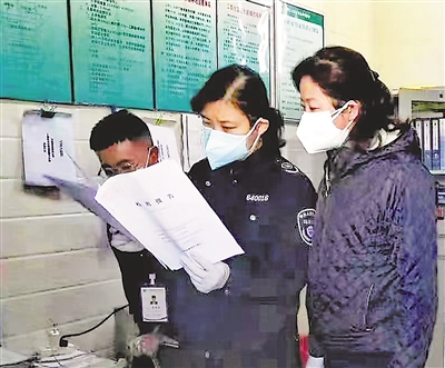     谢永春（中）检查企业污染物监测报告，做好生态环境保护工作。（资料图片）