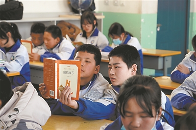     狼皮子梁学校学生同读一本书。