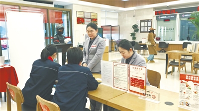 银行工作人员向客户介绍个人养老金政策。